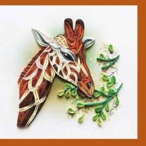 Artistic quilled giraffe eating leaves